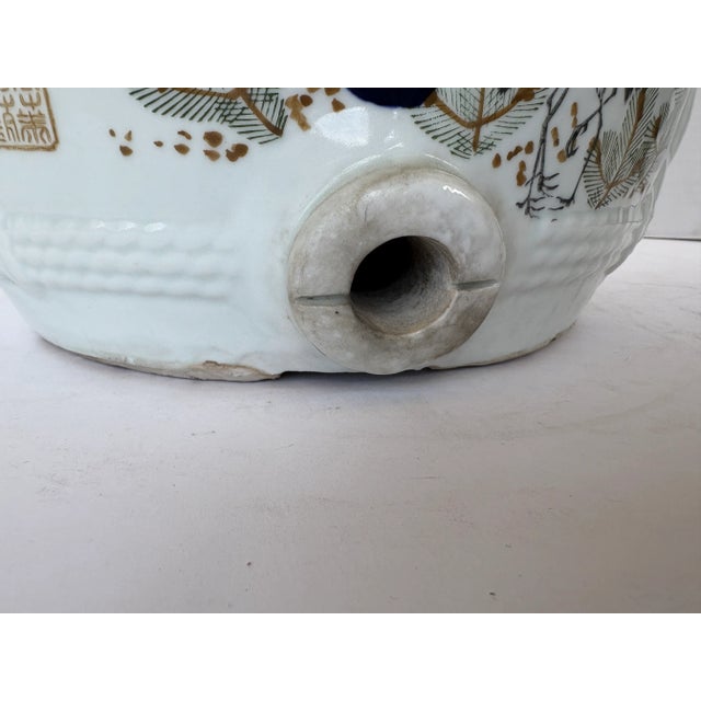 A large ceramic sake jug with a glazed finish, featuring Japanese calligraphy inscriptions along with designs of birds and...