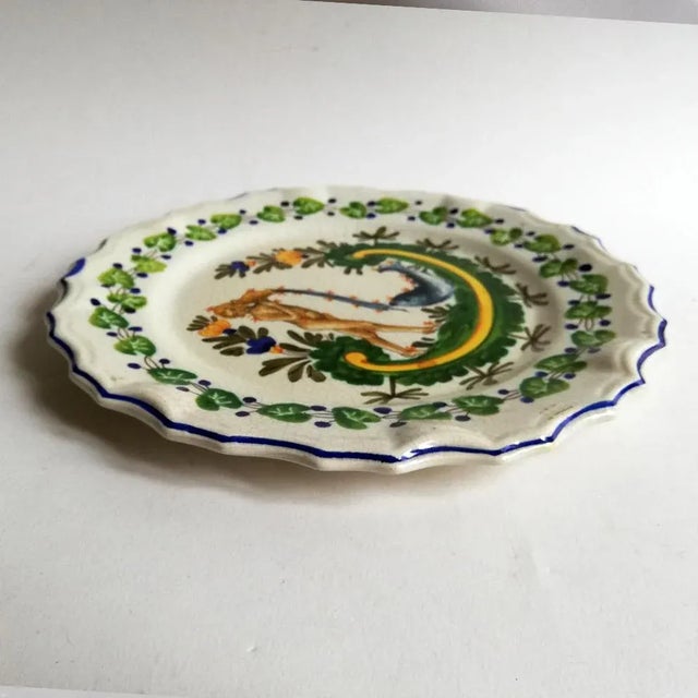 This ceramic wall platter or centerpiece comes with a Zodiac sign decoration, depicting Aquarius with fish.