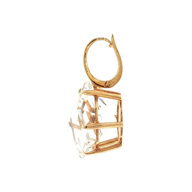 A late 20th-century pendant featuring a hexagonal fantasy-cut colorless quartz stone. The quartz is set in a 14k basket...