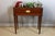 A Louis XVI style mahogany and mahogany veneer jardinière, decorated with truncated fluting, rests on four tapered, fluted...