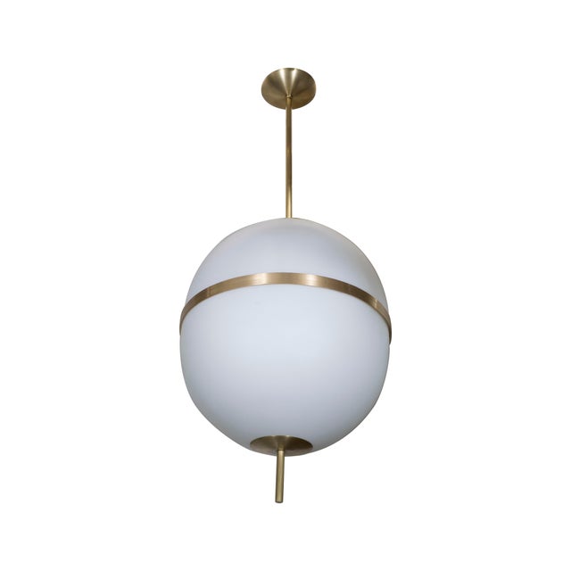 Pendant light fixture composed of opaline glass forming an ovoid shade by Spark Interior. Metal finish and overall drop...