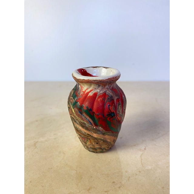 A striking vintage marbled porcelain bud vase featuring dramatic ribbon-like swirls of crimson, emerald green, charcoal,...