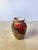 A striking vintage marbled porcelain bud vase featuring dramatic ribbon-like swirls of crimson, emerald green, charcoal,...