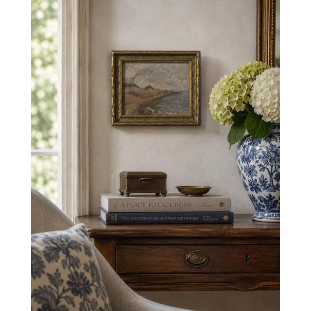 An intimate early 20th-century coastal landscape painted in oil on board, depicting a gently curving shoreline beneath an...