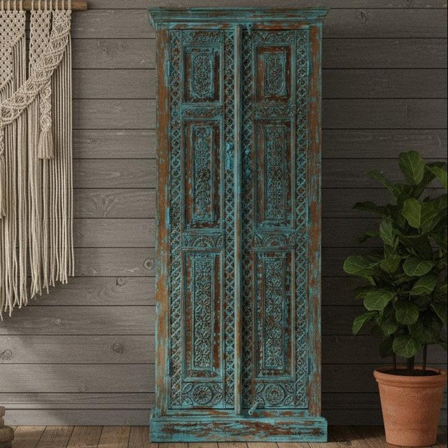 Elevate your space with this stunning antique blue wardrobe armoire, beautifully hand-carved with intricate floral motifs...