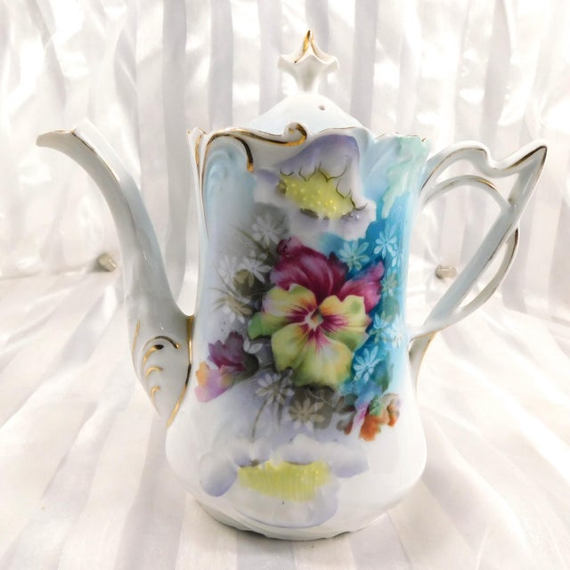 This is a light blue floral chocolate pot set. It is not marked, although it screams Reinhold Schlegelmilch in the Folded...