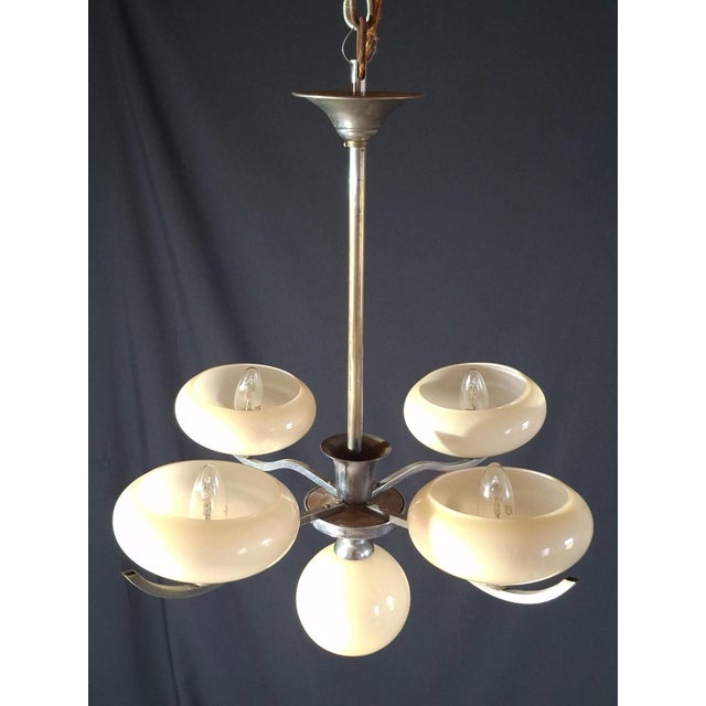 Vintage 1950s chandelier in chrome-plated metal, with five arms illuminated by five pale yellow opaline glass shades (four...