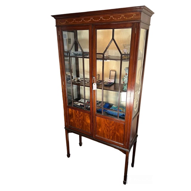 Edwardian Mahogany Cabinet with Inlaid panel at cresting over 2 glassed doors revealing 2 shelves, over 2 panels...