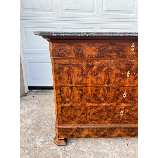 A handsome 19th-century French Louis Philippe commode, featuring richly figured burl walnut veneer, four spacious drawers,...