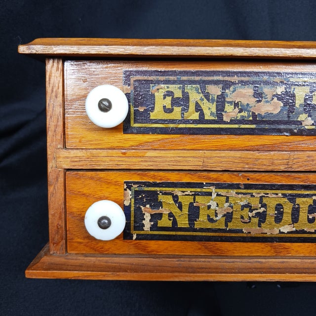 Showcasing a rich golden oak finish, this miniature spool cabinet boasts two drawers fitted with porcelain knobs and...