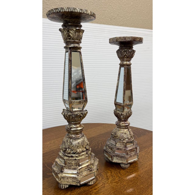 Design Plus Gallery presents a Pair of Mirrored Column Candleholders. Each candleholder has a tapered, faceted stem inset...