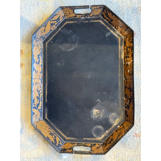 This is an antique octagonal tole tray. It has a black lacquer finish. It has hand painted gold floral deco and fruits. It...
