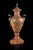 Hand-carved alabaster urn in a warm brandy hue, adorned with finely detailed antique bronze castings. The graceful,...