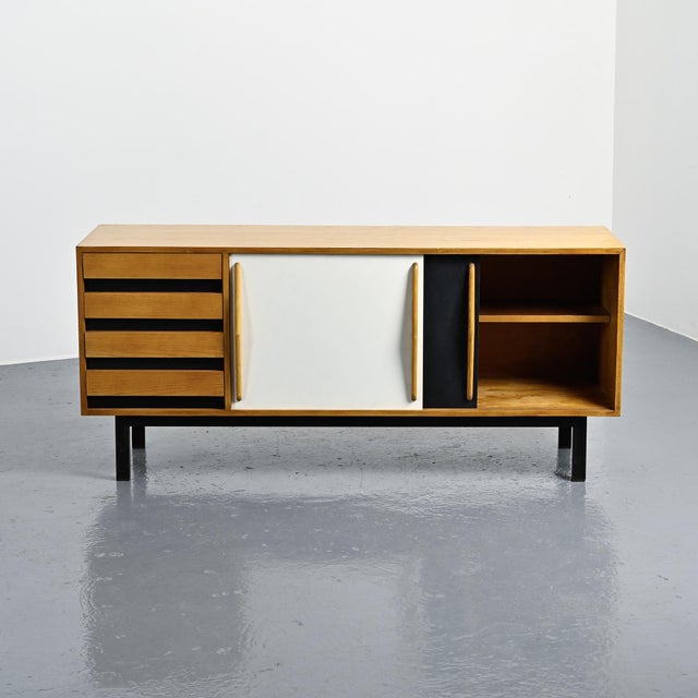 Cansado sideboard with an ash veneer body, opening with two sliding doors covered in black and white laminate and four...