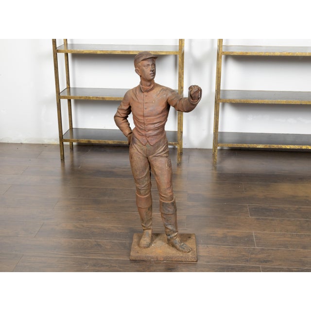 An English Turn of the Century iron sculpture depicting a jockey holding a ring in his left hand. Created in England...
