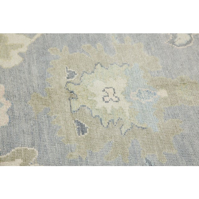 This modern Turkish Oushak rug is a stunning piece of art that has been handwoven using traditional techniques by skilled...