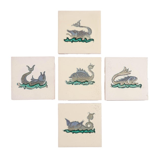 Set of 5 faience tiles of imaginary fish with raised outlines and colored in shades of blue, green, and black. Stamped on...