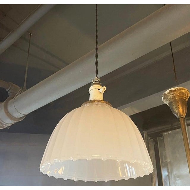 This elegant, early 20th century pendant light features a 10" height ribbed milk glass dome shade with scalloped edge...
