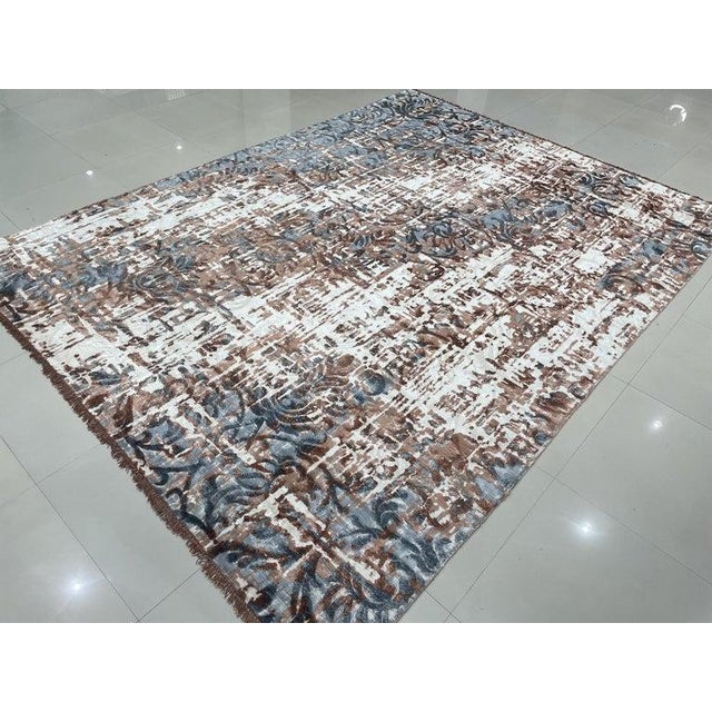 This hand knotted pile rug features a primary color palette of ivory, beige, cream, and white. Crafted from wool, this...