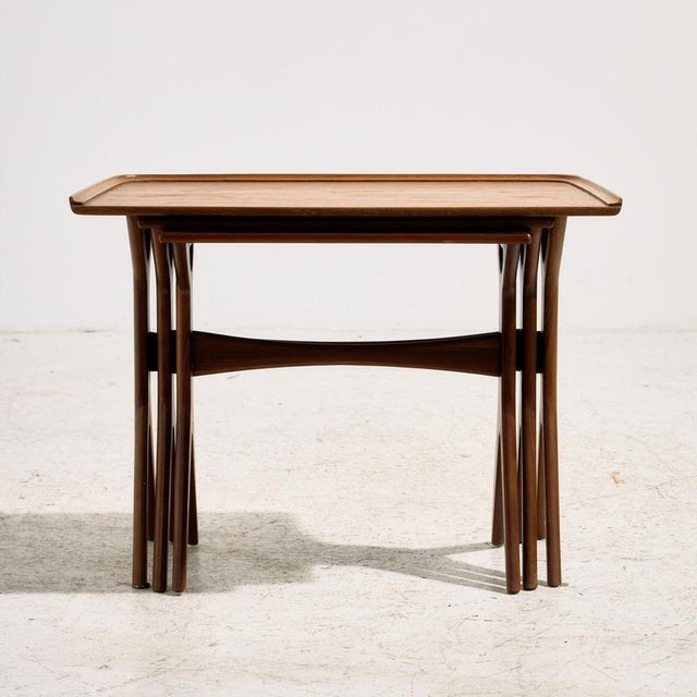 A teak nesting table designed by Johannes Andersen for CFC Silkeborg in the 1960s. The set consists of three pieces and...