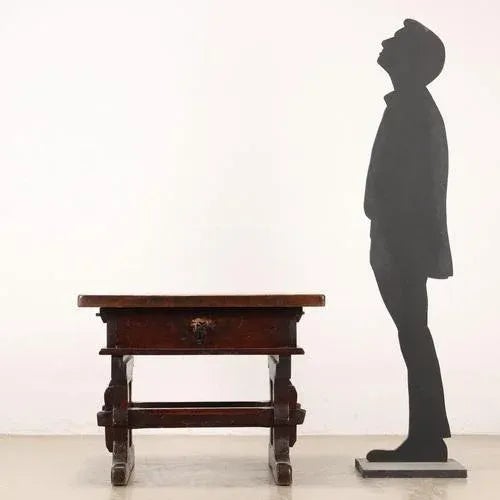 Style coffee table supported by shaped uprights connected by a pair of crosspieces, there is a drawer in the under-top...