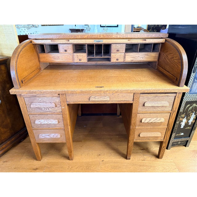 A handsome antique roll top desk crafted in solid quarter-sawn oak with a rich warm honey finish. The tambour lid locks...
