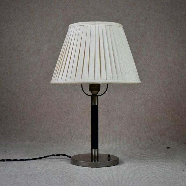 Very nice table lamp by Harald Notini for Böhlmarks. Nickel-plated base and the steam in black-stained wood and pleated...