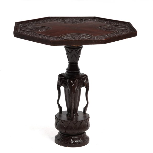 A vintage Anglo-Indian lamp or side table from the mid 20th century. The table features four matching relief carved panels...