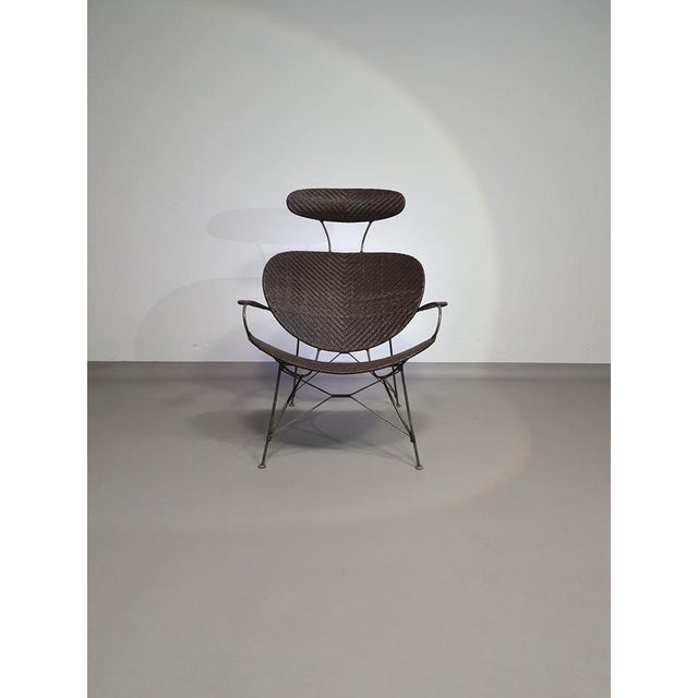 Armchair designed by Yuzuru Yamakawa Metal frame. Seat and back in braided rattan. The armchair; height 96, width 77, seat...