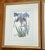 A pair of framed botanical iris prints in soft purple and blue. They are matted and set in gold wood frames. Hang them...