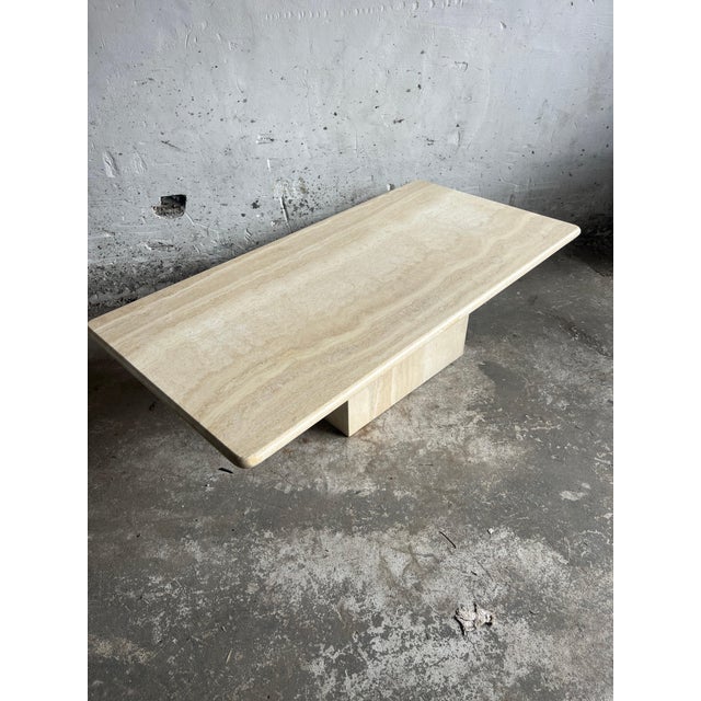A refined italian coffee table crafted in solid travertine, dating from the 1970s. This piece showcases the natural beauty...