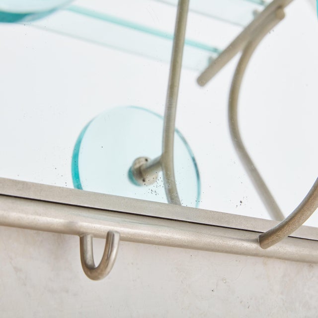 A 1970s Italian rectangular wall mounted coat rack constructed of antiqued mirror glass and patinated chrome. This coat...