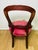 Antique Victorian-style balloon back parlor chair featuring a richly finished carved wood mahogany frame with graceful...