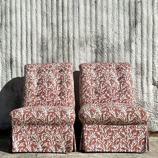 This pair of vintage tufted slipper chairs showcases a charming coastal coral print, blending timeless elegance with...