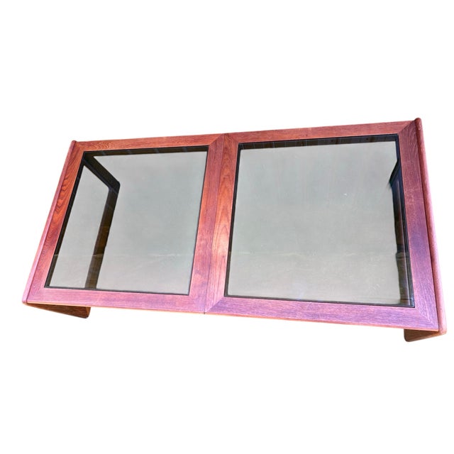 A rare double paned smoke glass and teak coffee table by Komfort Designs of Denmark. Dating from the mid-20th century....