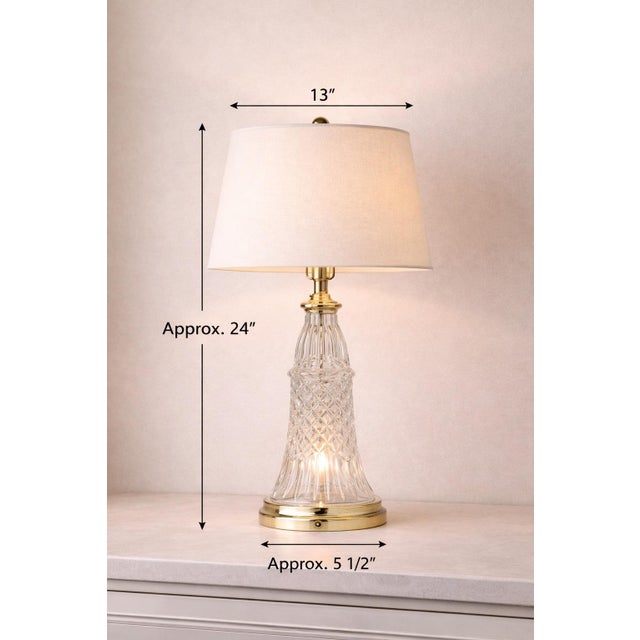 A classic mid-century crystal table lamp with illuminated cut-glass base and warm brass details. Both the base and upper...