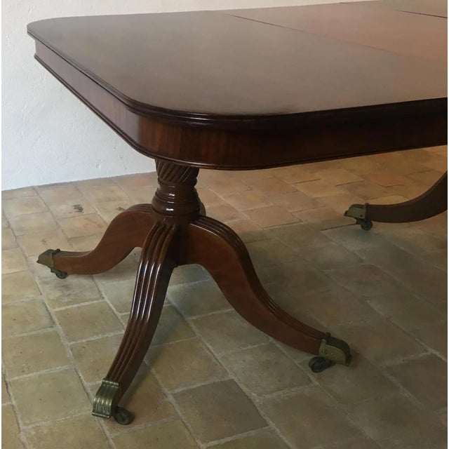 A superb quality English Regency dining table made of solid Cuban flame mahogany supported by two turned pillars/pedestals...