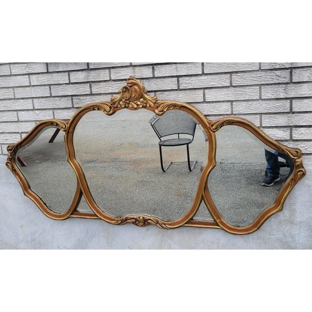 Elegant 1920 French Louis XV-style triple-panel wall mirror featuring a beautifully carved gilded wood frame with graceful...