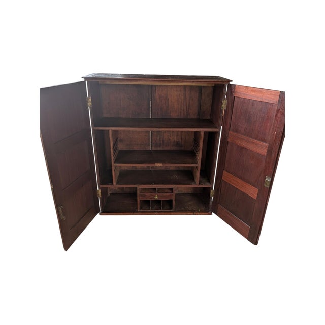 An authentic antique document and specimen cabinet featuring rich natural grain, recessed-panel doors, and an intricate,...