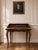 A beautifully detailed French Louis XV style writing desk featuring warm wood veneers, floral marquetry inlay, cabriole...
