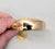 Goldtone cuff bracelet with front hook clasp. Marked "NAPIER©" inside in the back of the bracelet. Measures: 11/16 inches...