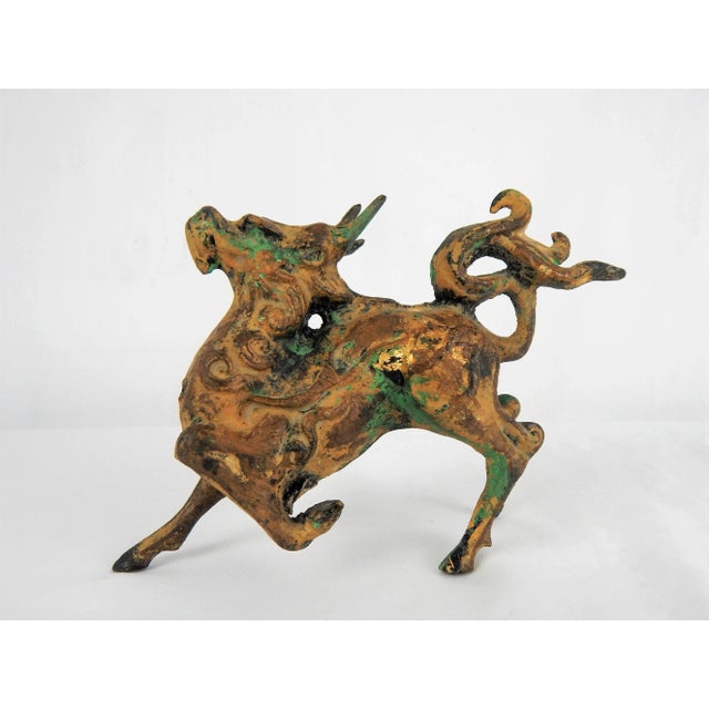 Captivating stylized cast-metal Asian prancing horse figure featuring a rich gilt patina with green oxidation for added...