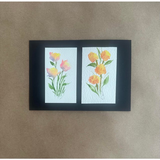 A cheerful pair of small floral studies presented in a bold black mat. Each painting features loose, luminous blossoms in...