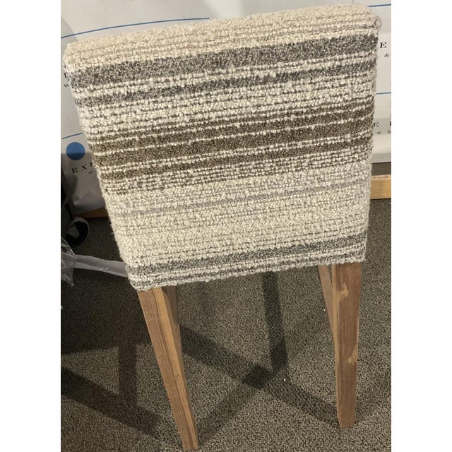 The Thibaut barstools with a striped neutral fabric and walnut base are sure to make a statement in any space.