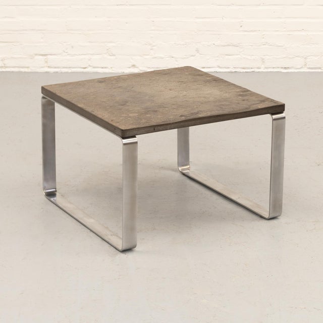 Small coffee table by Peter Draenert, combining fossil-bearing slate with brushed stainless steel. The grey-green stone...
