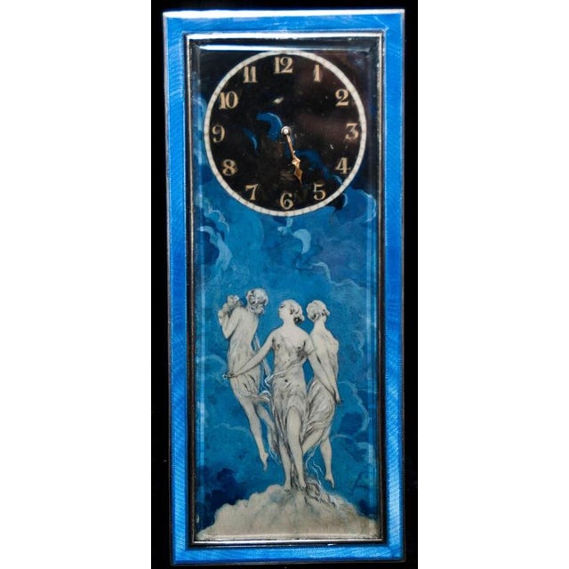 Silver clock painted blue glaze with three Graces in the centre and the clock on the top. The clock is in silver painted...