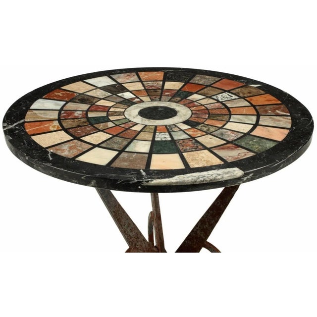 A visually striking wrought iron table with a magnificent 19th century Italian Grand Tour pietra dura style specimen top,...