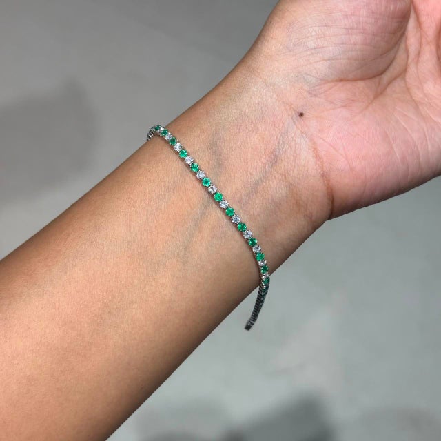 This tennis bracelet showcases 1.76 carats of natural emeralds, set in 14k white gold. Each emerald measuring...