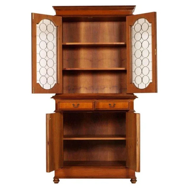 This 1940s walnut veneer armoire features two drawers and has been polished with wax. There are grates on the upper...