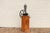 Wonderful antique standing coffee grinder featuring a large cast iron flywheel, hand-crank mechanism, and rustic solid...
